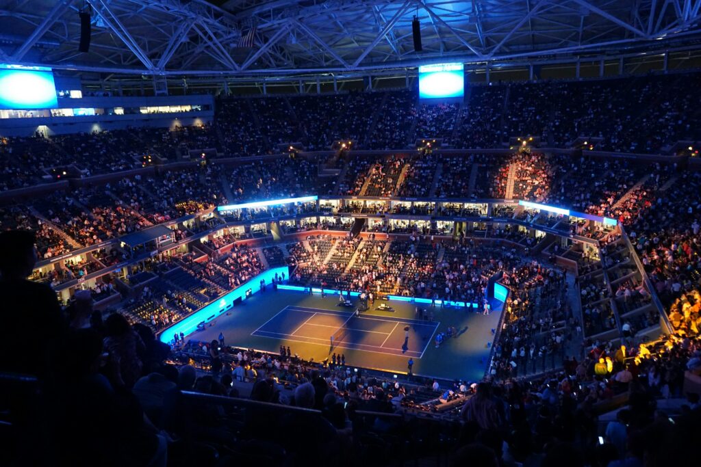 Floodlit tennis stadium full for a night match