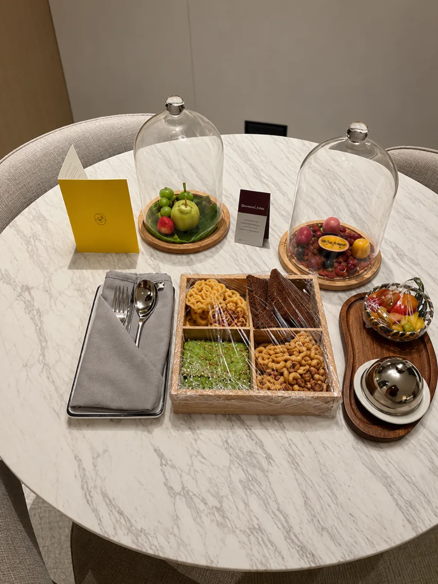 Welcome spread of chocolates, dried fruit, fresh fruit and biscuits on a marble table at voco Kuching